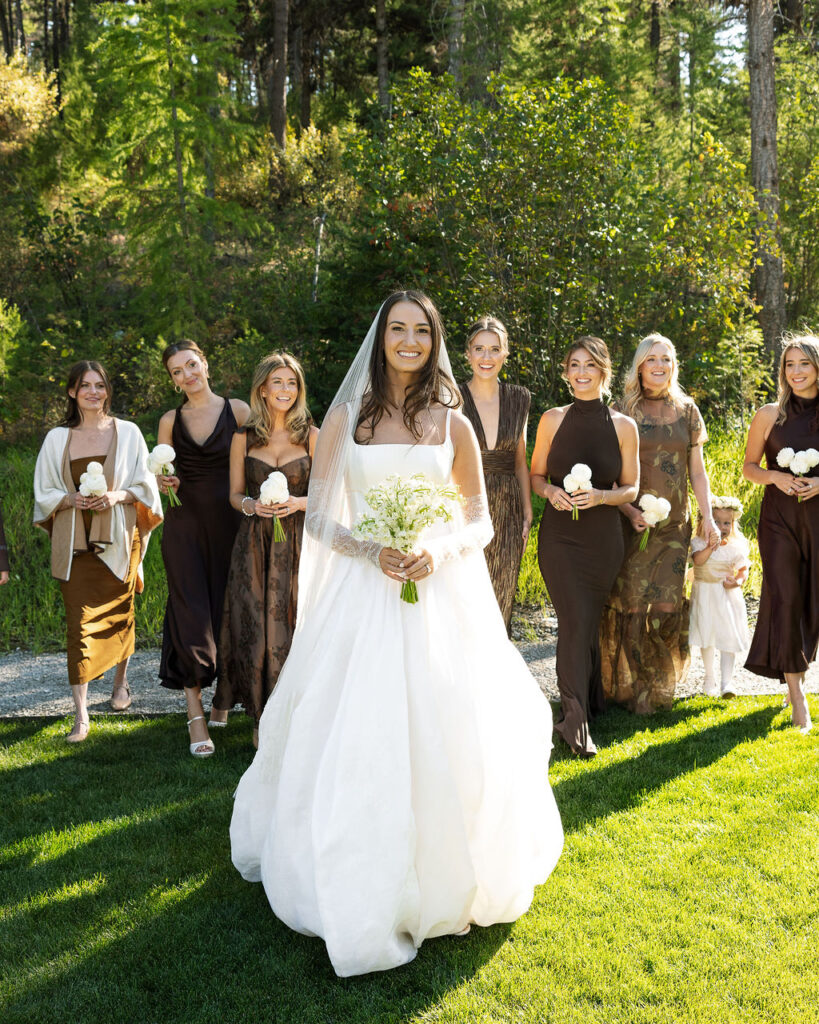 Bride walking down the aisle with her bouquet followed by bridesmaids