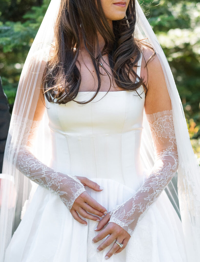 Close-up of the bride’s lace sleeves and wedding gown details