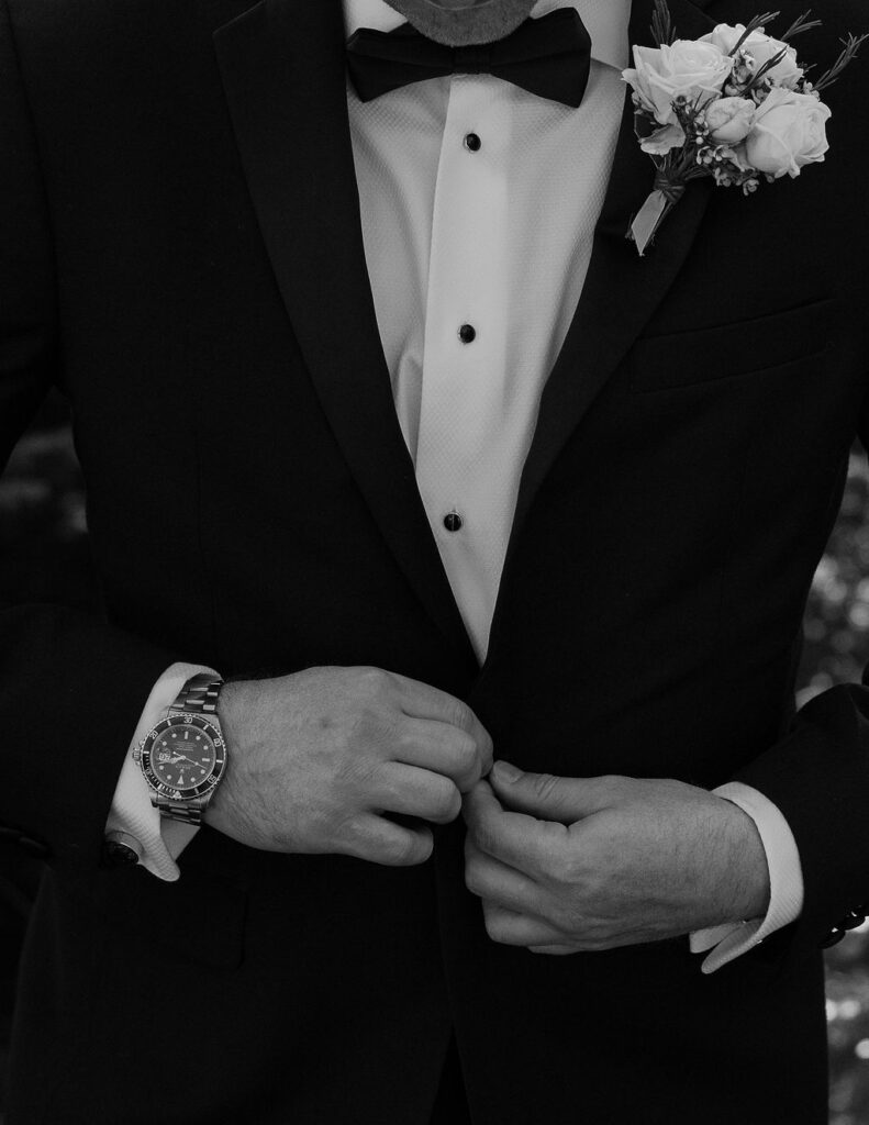 Groom adjusting his tuxedo jacket before the ceremony