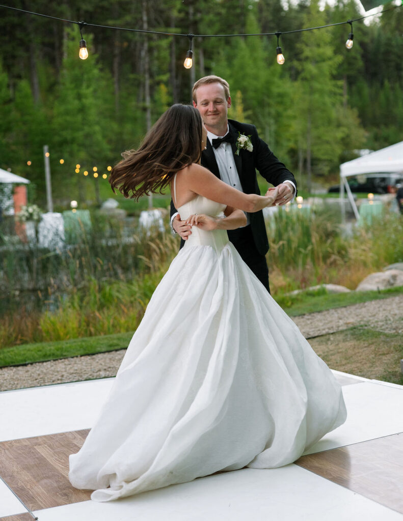 Bride and groom dancing together outdoors at the reception
