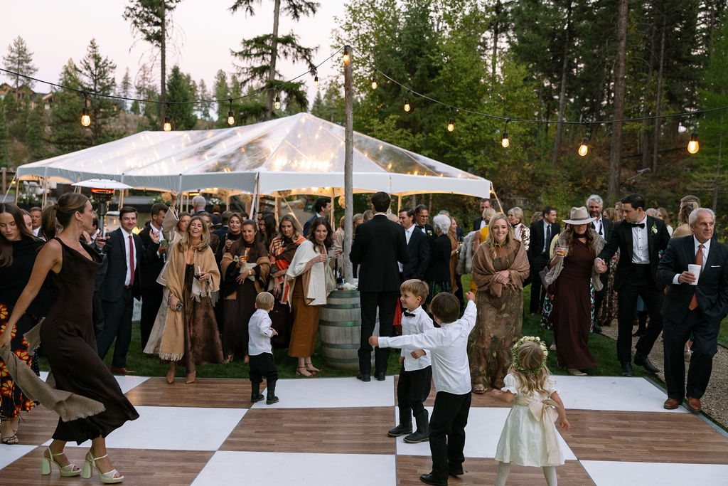 Guests gathered under a clear tent for the outdoor wedding reception