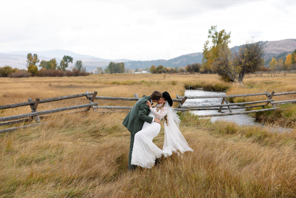 Bride and groom dip kiss during The Meadows on Rock Creek wedding ceremony