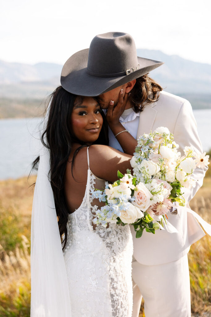 Bride holding bouquet while embracing groom during intimate fall elopement in Glacier National Park