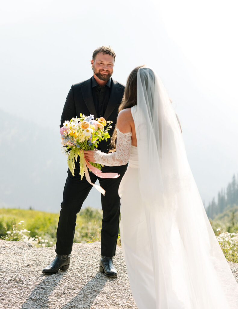 Bride and groom standing together with bouquet during their Glacier National Park elopement