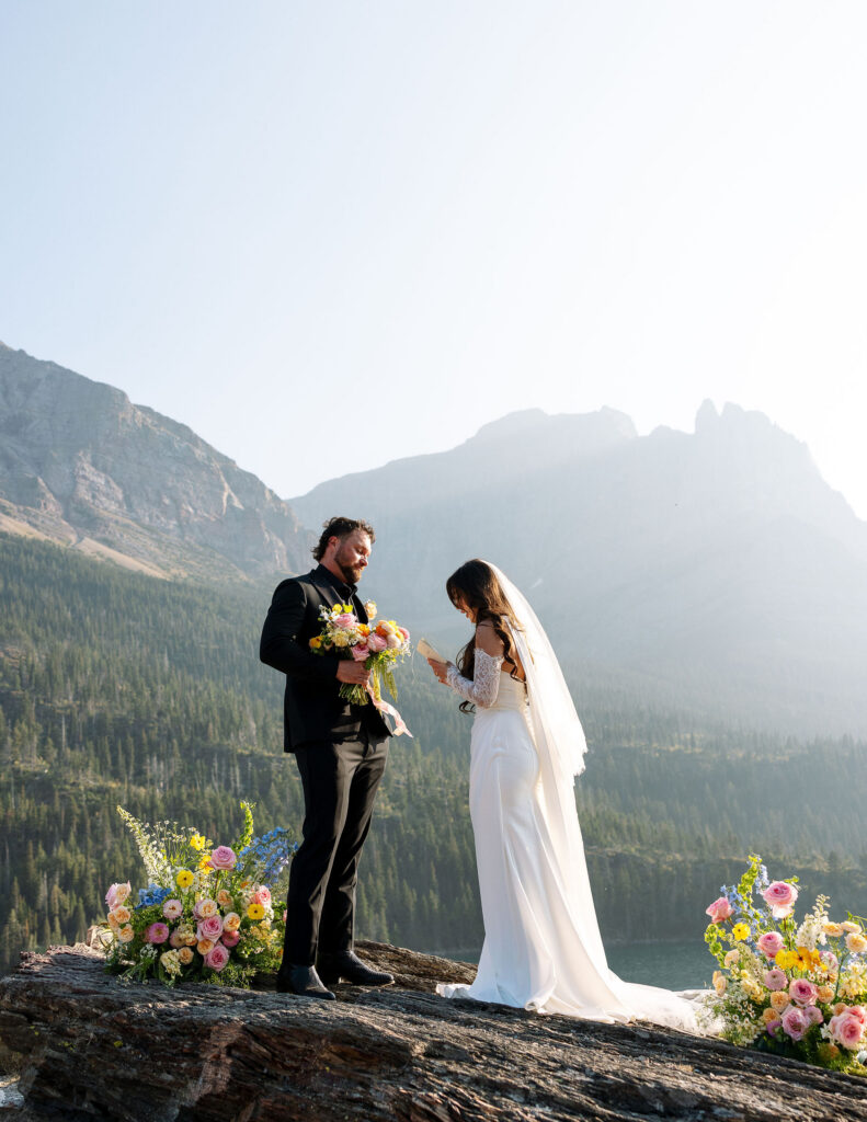 Bride and groom exchanging vows with mountain views behind them during a Glacier National Park elopement ceremony