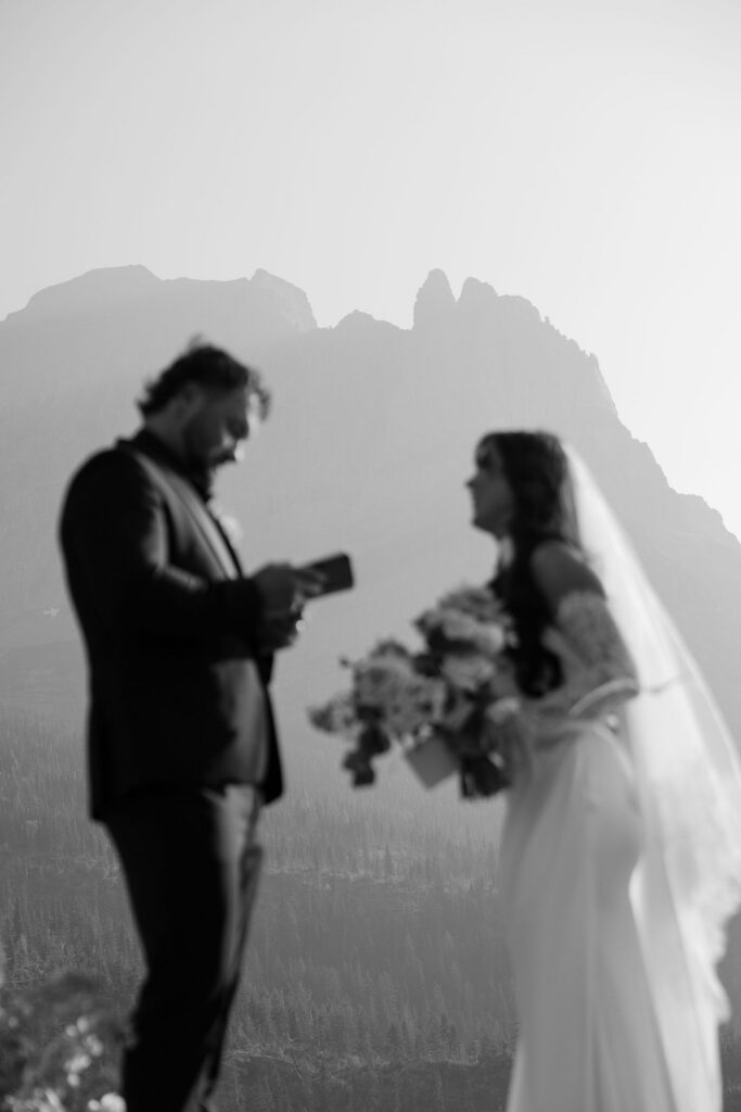 Black and white silhouette of bride and groom exchanging vows during a Glacier National Park elopement