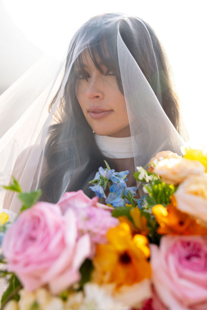 Close portrait of bride under veil holding a colorful bouquet during a Glacier National Park elopement