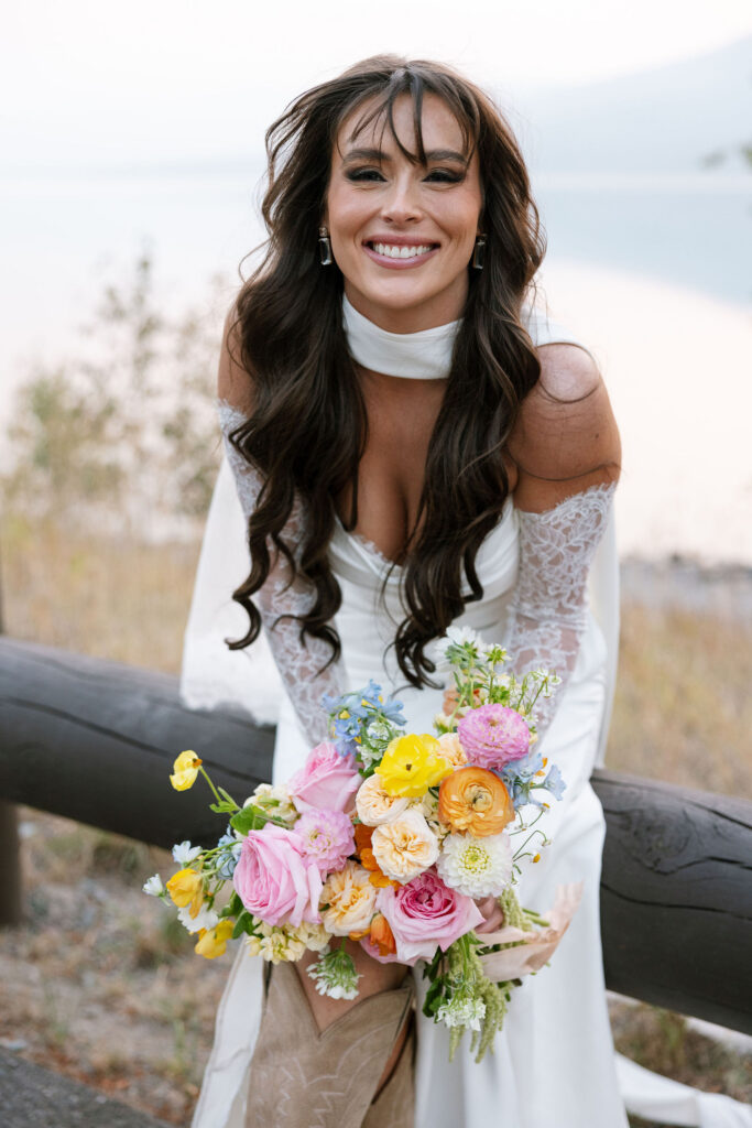 Bride smiling while holding a colorful bouquet during a Glacier National Park elopement portrait