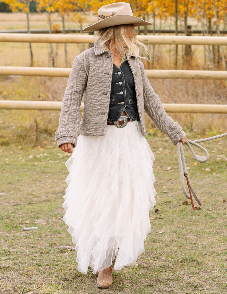Detail photo of Haley Jessat walking with a lead rope while wearing a western outfit during a Montana ranch photoshoot