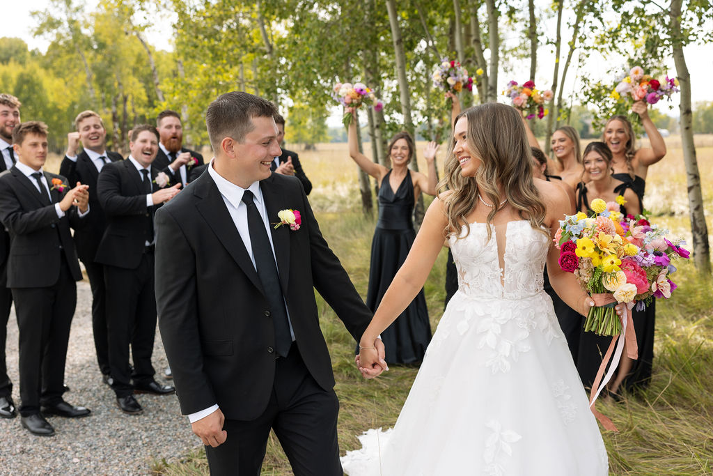 Bride and groom walking hand in hand down the aisle after their outdoor wedding ceremony in Whitefish Montana