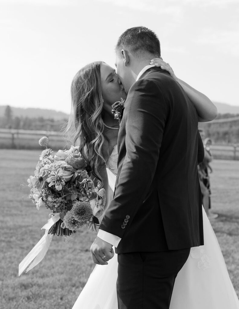 Black and white portrait of bride and groom embracing during sunset wedding portraits in Whitefish Montana