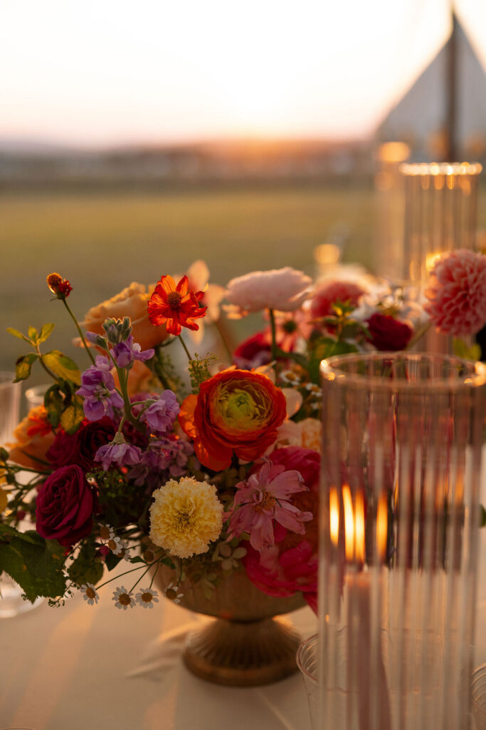 Colorful summer wedding floral arrangement with candles and vibrant blooms during a Whitefish Montana wedding reception