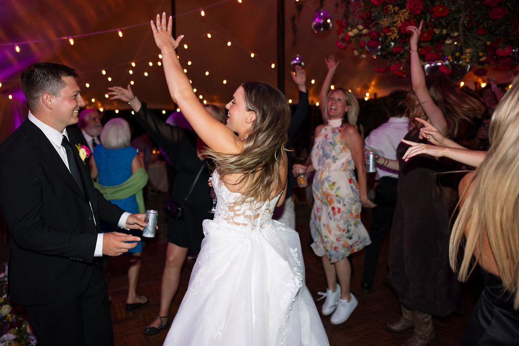 Bride dancing with guests on the dance floor during a lively summer wedding reception in Whitefish Montana photographed by Haley Jessat