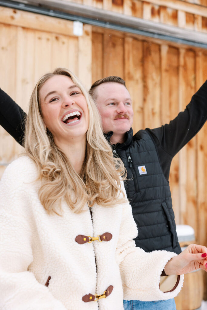 Couple laughing together after surprise winter proposal in Whitefish Montana