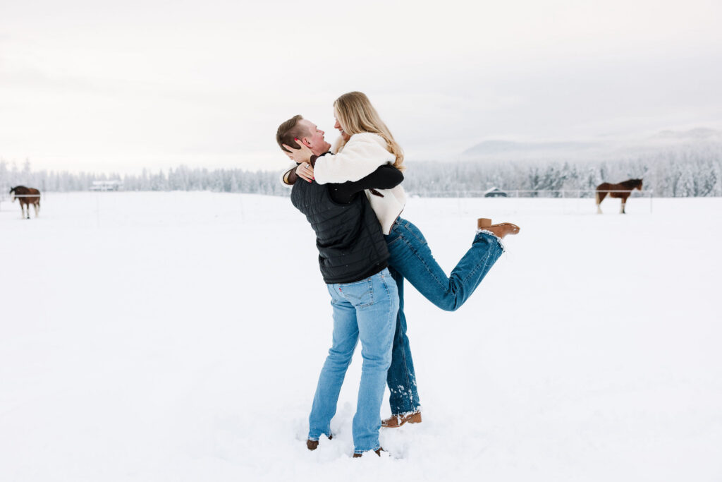 Couple embracing and celebrating engagement in snowy Whitefish Montana