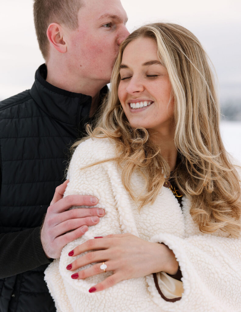 Close up of couple embracing during winter engagement photos in Whitefish Montana